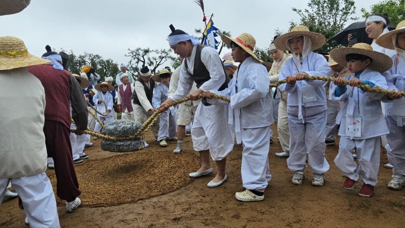 [화성=뉴시스]문영호 기자=화성시 팔탄면향토민요보존회가 10일 개최한 '제9회 화성팔탄민요 전통 모심기 재현 및 체험행사'에 참가한 아이들이 보존회 회원들과 함께 지경다지기를 하고 있다.2025.05.10.sonanom@newsis.com