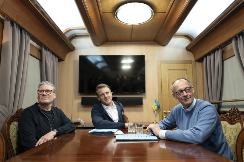 지난 9일(현지시간) 우크라이나 키이우로 향하는 열차 안에서 영국의 키어 스타머 총리, 프랑스의 에마뉘엘 마크롱 대통령, 독일의 프리드리히 메르츠 총리(왼쪽부터)가 사진을 찍고 있다.AP뉴시스