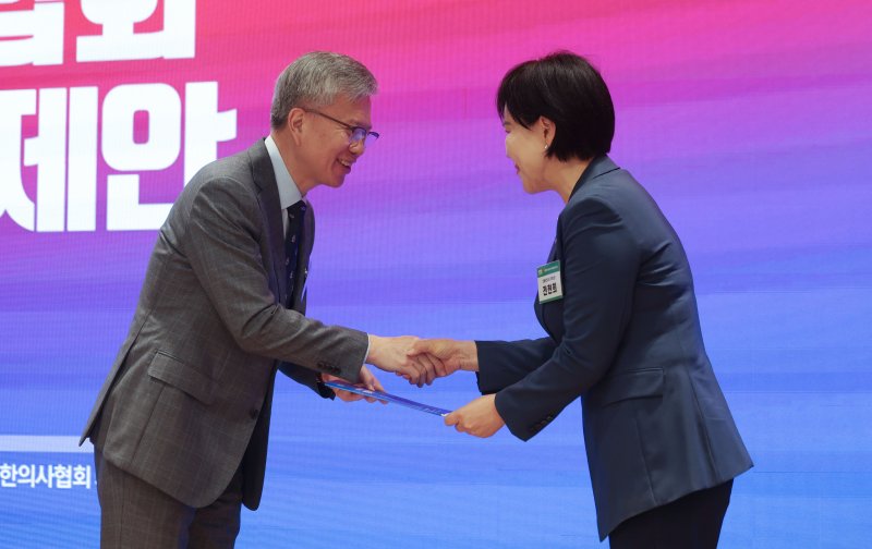[서울=뉴시스] 김선웅 기자 = 김택우 대한의사협회장이 10일 서울 용산구 대한의사협회에서 열린 제21대 대통령 선거 보건의료 분야 정책제안 보고회에서 더불어민주당 공동선대위원장 전현희 의원에게 보건의료 분야 정책제안서를 전달하고 있다. 2025.05.10. mangusta@newsis.com