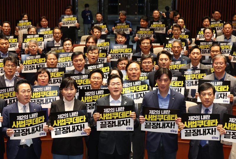[서울=뉴시스] 고승민 기자 = 더불어민주당 박찬대 대표 직무대행 겸 원내대표와 의원들이 4일 서울 여의도 국회에서 열린 긴급 의원총회에서 피켓을 들고 구호를 외치고 있다. 2025.05.04. kkssmm99@newsis.com