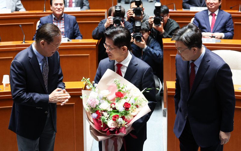 [서울=뉴시스] 권창회 기자 = 김문수 국민의힘 대선 후보가 9일 오전 서울 여의도 국회에서 열린 의원총회에서 권영세 비상대책위원장과 권성동 원내대표에게 꽃다발을 받고 자리로 이동하고 있다. 2025.05.09. kch0523@newsis.com