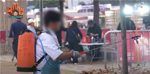 지역 축제에서 농약 분무기에 사과주스를 담아 살포하는 더본코리아 직원 (출처=연합뉴스)