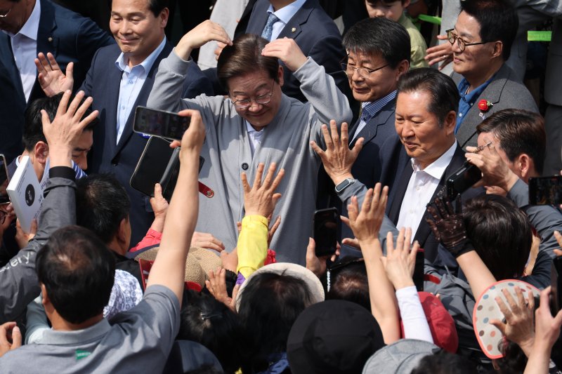 [영암=뉴시스] 조성우 기자 = 민심을 청취하는 '경청 투어'에 나선 이재명 더불어민주당 대선후보가 11일 전남 영암군 독천터미널 인근에서 군민들과 인사를 나누고 있다. 2025.05.11. xconfind@newsis.com