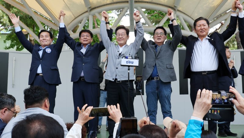 [해남=뉴시스] 조성우 기자 = 민심을 청취하는 '경청 투어'에 나선 이재명 더불어민주당 대선후보가 11일 전남 해남군 해남읍 인근 광장에서 연설을 마친 뒤 박지원, 서삼석, 정청래 의원의 등과 손을 맞잡고 주민들에게 인사하고 있다. 2025.05.11. xconfind@newsis.com