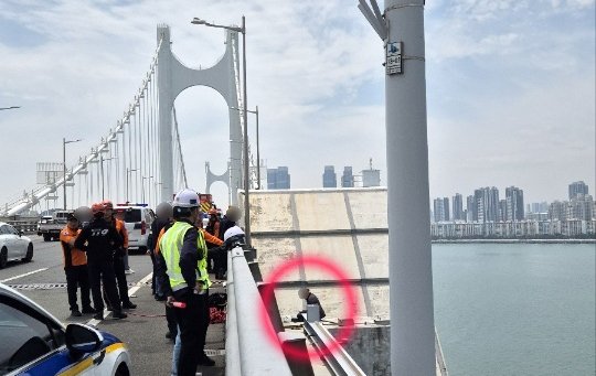 [부산=뉴시스] 11일 부산 광안대교 상판 난간에 들어간 A(50대)씨가 고공시위를 벌이고 있다. (사진=부산경찰청 제공) 2025.05.11. photo@newsis.com *재판매 및 DB 금지