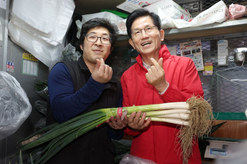 [서울=뉴시스] 권창회 기자 = 제21대 대통령선거 공식 선거운동 첫날인 12일 오전 김문수 국민의힘 대선 후보가 서울 송파구 가락시장을 방문해 대파를 구매하며 기념촬영을 하고 있다. 2025.05.12. kch0523@newsis.com