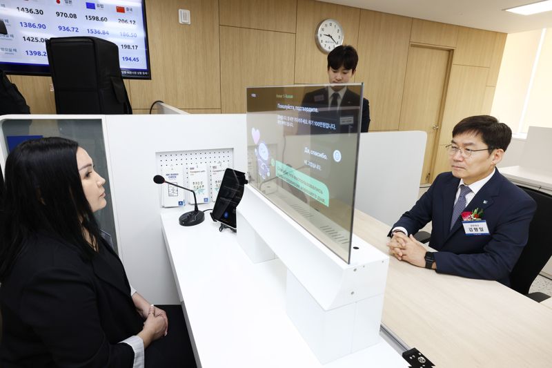 13일 경기도 안산시에 위치한 기업은행 안산외국인금융센터에서 김형일 IBK기업은행 전무이사(오른쪽)가 실시간 통번역서비스 시스템을 시연하고 있다. IBK기업은행 제공
