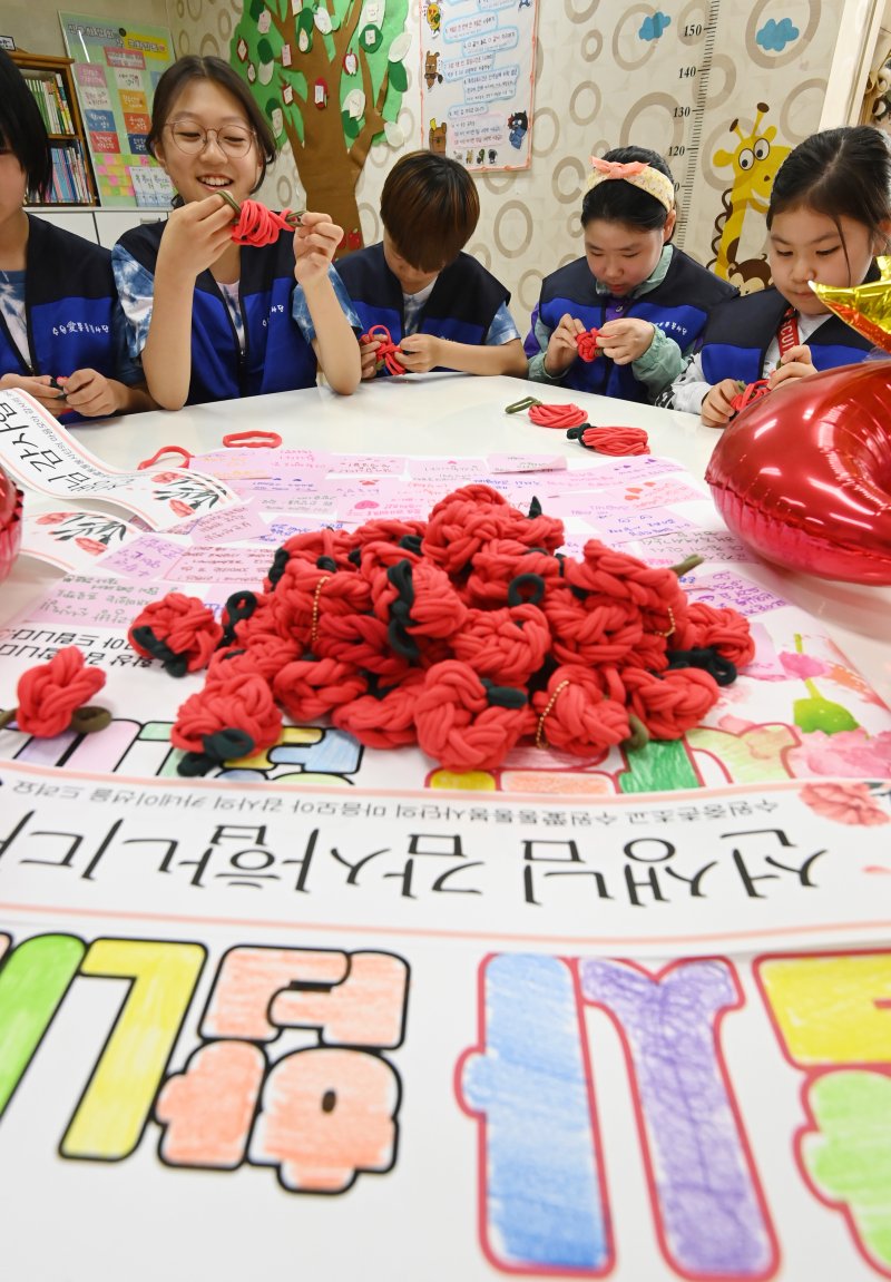 [수원=뉴시스] 김종택 기자 = 스승의 날을 하루 앞둔 14일 경기 수원시 권선구 중촌초등학교에서 통통봉사단 학생들이 선생님에게 전달할 카네이션을 만들고 있다. 2025.05.14. jtk@newsis.com