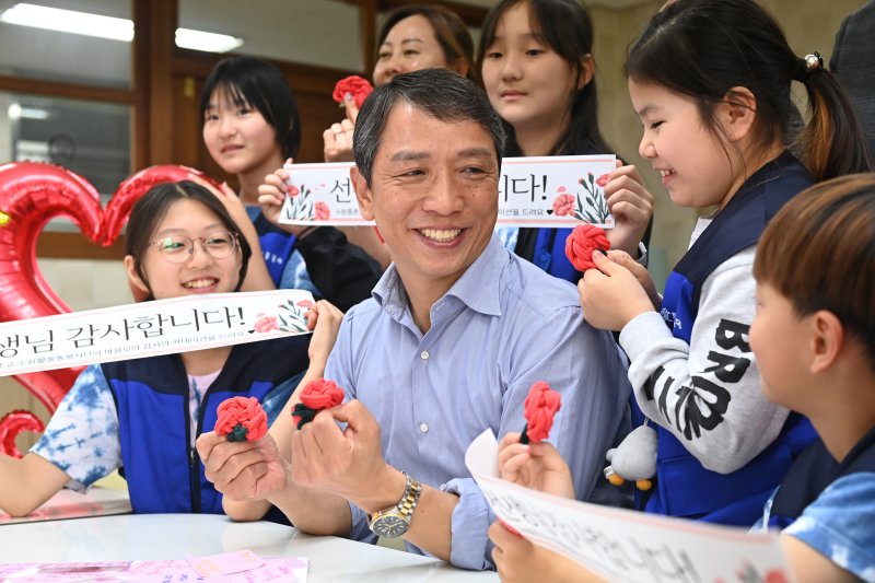 [수원=뉴시스] 김종택 기자 = 스승의 날을 하루 앞둔 14일 경기 수원시 권선구 중촌초등학교에서 통통봉사단 학생들이 직접 만든 카네이션과 감사의 편지를 선생님에게 전달하고 있다. 2025.05.14. jtk@newsis.com