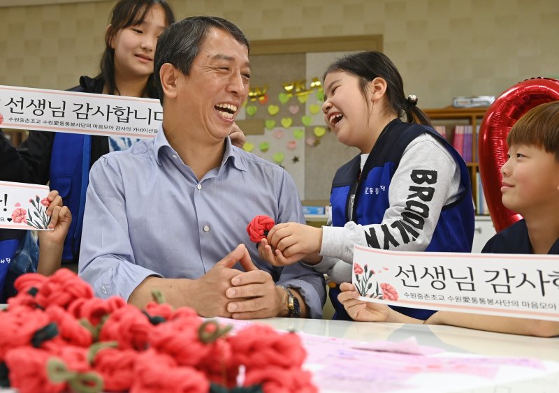 [수원=뉴시스] 김종택 기자 = 스승의 날을 하루 앞둔 14일 경기 수원시 권선구 중촌초등학교에서 통통봉사단 학생들이 직접 만든 카네이션과 감사의 편지를 선생님에게 전달하고 있다. 2025.05.14. jtk@newsis.com