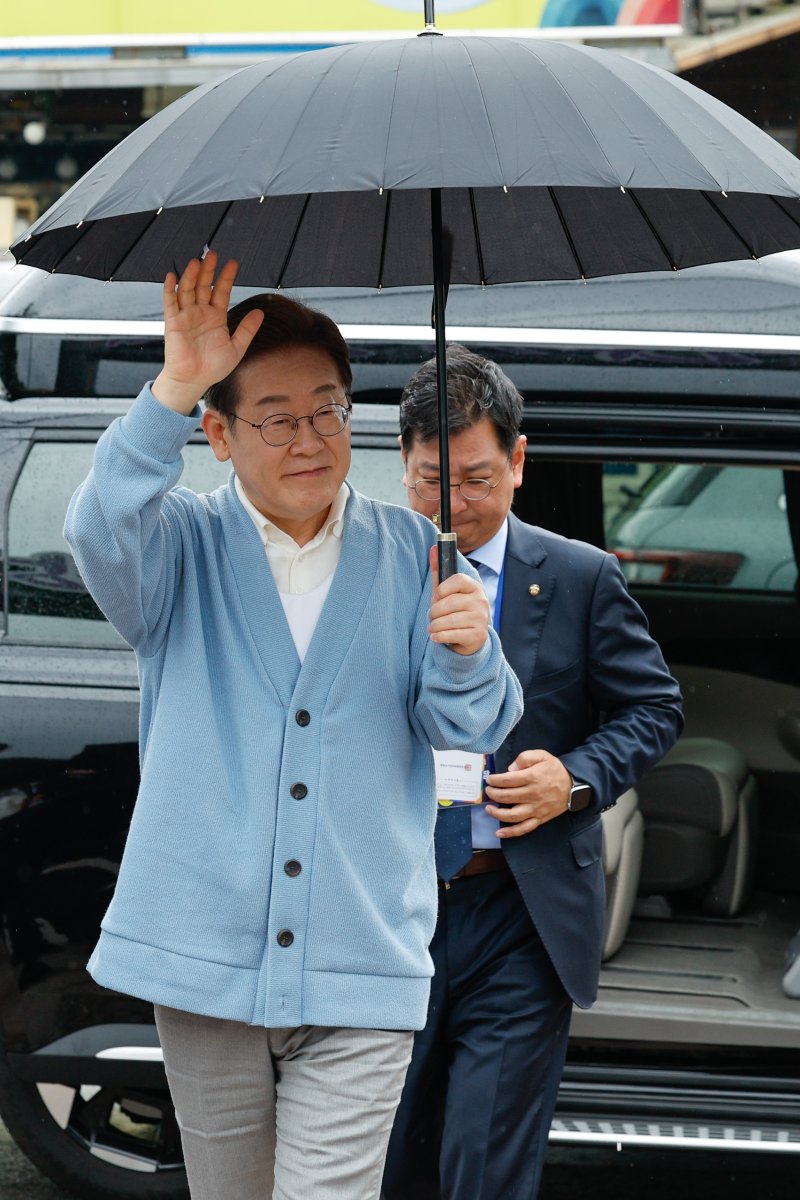 [하동=뉴시스] 권창회 기자 =이재명 더불어민주당 대선 후보가 15일 경남 하동군 화개장터 입구에서 유튜브 'K-이니셔TV 케미폭발 동서화합 화개장터 라이브'를 하기 위해 차에서 내려 인사하고 있다. (공동취재) 2025.05.15. photo@newsis.com