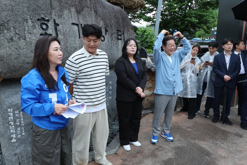 [하동=뉴시스] 권창회 기자 =이재명 더불어민주당 대선 후보가 15일 경남 하동군 화개장터 입구에서 유튜브 'K-이니셔TV 케미폭발 동서화합 화개장터 라이브'를 하고 있다. (공동취재) 2025.05.15. photo@newsis.com