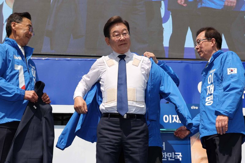 [서울=뉴시스] 조성우 기자 = 이재명 더불어민주당 대선후보가 제21대 대통령선거 공식 선거운동이 시작된 12일 오전 서울 종로구 청계광장에서 열린 중앙선거대책위원회 출정식에서 선거운동복을 입고 있다. 2025.05.12. xconfind@newsis.com