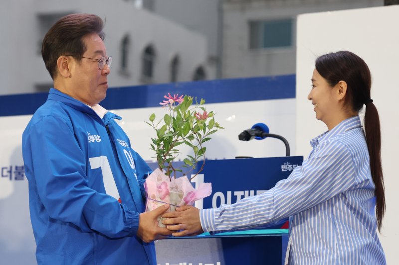 [목포=뉴시스] 권창회 기자 = 이재명 더불어민주당 대선 후보가 15일 전남 목포시 평화광장에서 열린 유세에서 김대중 전 대통령을 상징하는 인동초를 선물받고 있다. 2025.05.15. kch0523@newsis.com