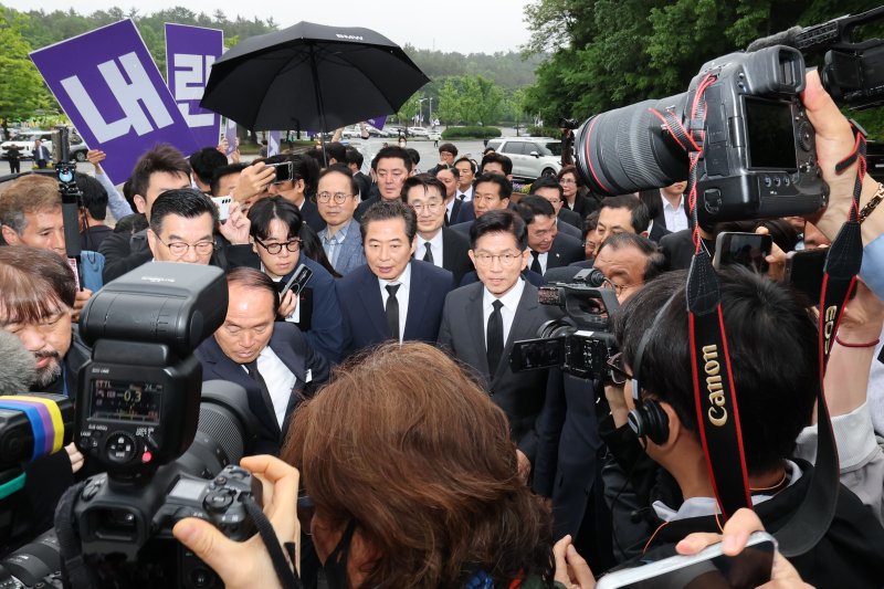 김문수 국민의힘 대통령 후보가 17일 오전 김 후보의 광주 방문을 반대하는 대학생들의 피켓 시위를 뒤로 하고 5.18민주묘지로 이동하고 있다. 2025.5.17/뉴스1 ⓒ News1 이광호 기자