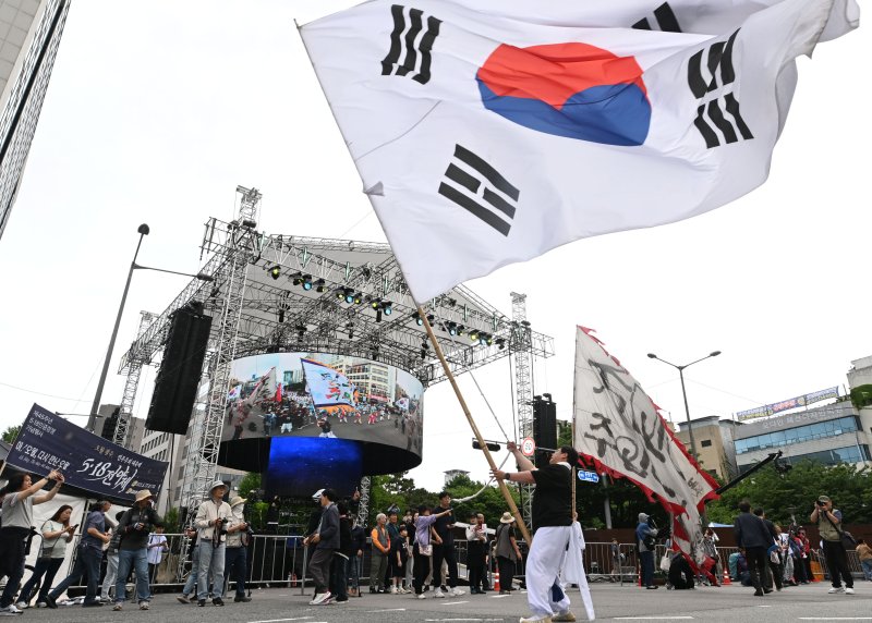 [광주=뉴시스] 이영주 기자 = 17일 오후 광주 동구 금남로에서 5·18민주화운동 45주기를 기념하는 풍물패가 대형 태극기를 흔들고 있다. 2025.05.17. leeyj2578@newsis.com