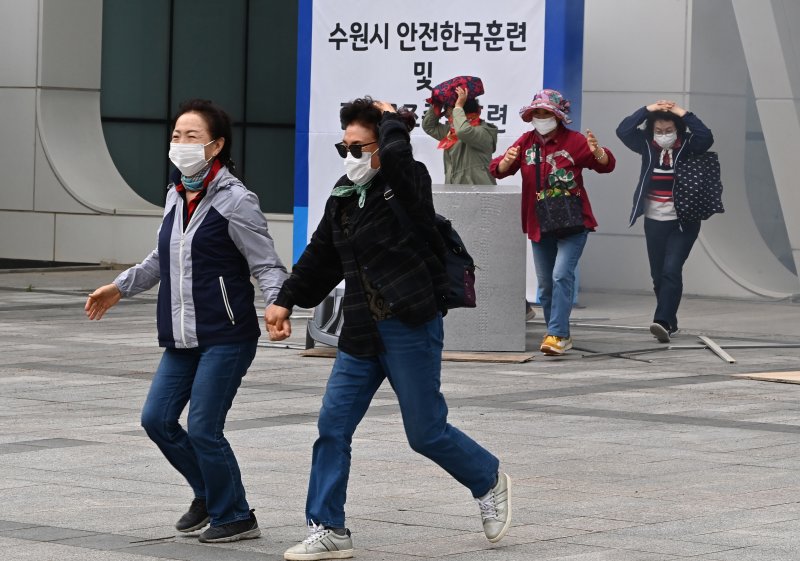 [수원=뉴시스] 김종택 기자 = 19일 경기 수원시 SK아트리움에서 열린 재난대응 안전한국훈련에서 시민들이 지진대피훈련을 하고 있다. 2025.05.19. jtk@newsis.com