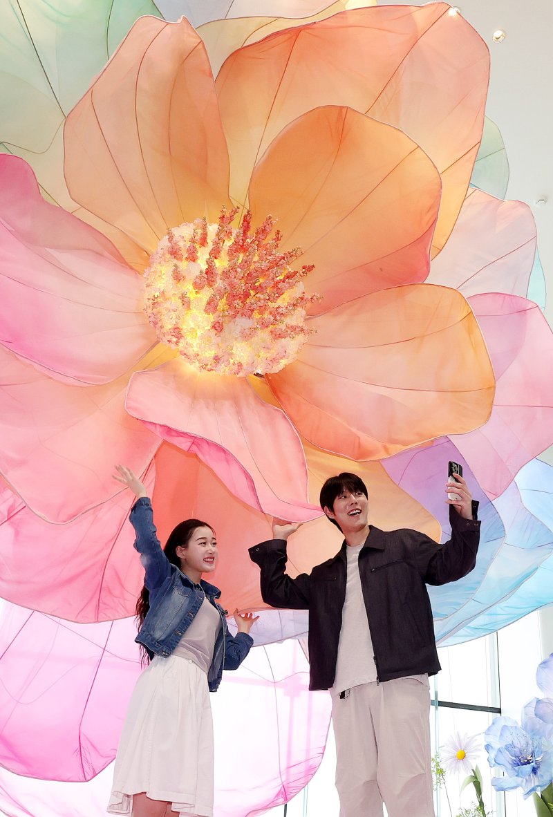 20일 서울 송파구 롯데월드타워 전망대 서울스카이에 마련된 플라워 체험형 공간인 '블루밍 유니버스: 빅플라워' 앞에서 모델들이 포즈를 취하고 있다. 2025.5.20/뉴스1 ⓒ News1 박지혜 기자