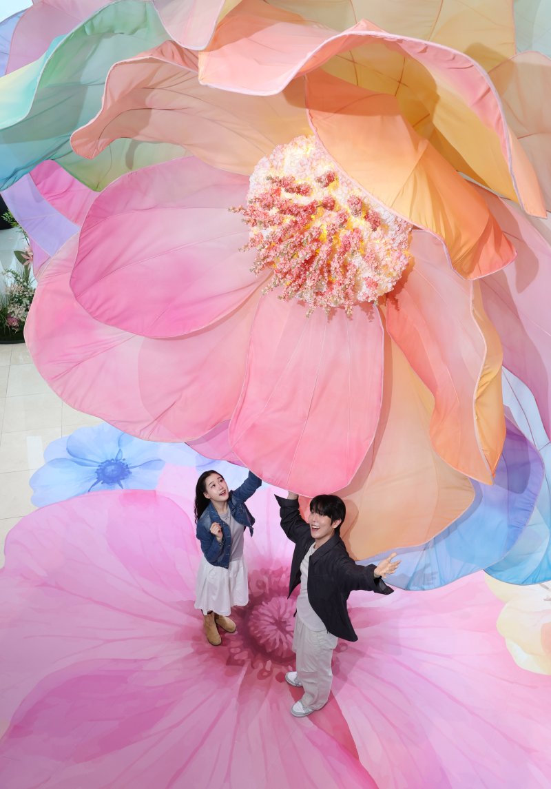 20일 서울 송파구 롯데월드타워 전망대 서울스카이에 마련된 플라워 체험형 공간인 '블루밍 유니버스: 빅플라워' 앞에서 모델들이 포즈를 취하고 있다. 2025.5.20/뉴스1 ⓒ News1 박지혜 기자