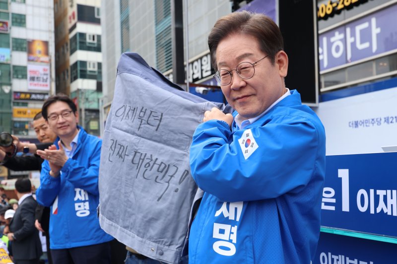 이재명 더불어민주당 대통령 후보가 민주당 험지로 꼽히는 부산·경남(PK) 지역 유세에 나선 14일 경남 창원시 상남분수광장에서 열린 집중유세에서 송순호 경남도당위원장으로부터 '이제부터 진짜 대한민국!' 문구가 써진 작업복을 전달 받고 있다. (공동취재) 2025.5.14/뉴스1 ⓒ News1 안은나 기자