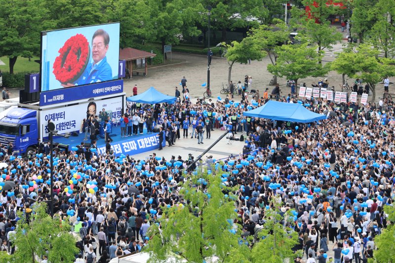 [고양=뉴시스] 조성우 기자 = 이재명 더불어민주당 대선후보가 20일 경기 고양시 일산동구 일산문화광장 앞에서 열린 집중유세에서 장미로 만든 투표기호 화환을 선물받고 있다. (공동취재) 2025.05.20. photo@newsis.com