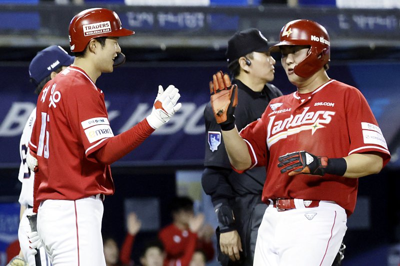 [서울=뉴시스] 최동준 기자 = 20일 서울 송파구 잠실야구장에서 열린 2025 KBO리그 SSG 랜더스와 두산 베어스의 경기, 8회초 2사 만루 상황 SSG 최준우의 희생플라이 때 득점한 고명준이 채현우와 하이파이브하고 있다. 2025.05.20. photocdj@newsis.com