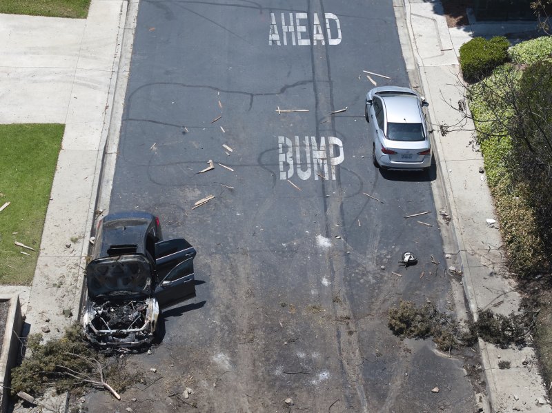 [샌디에이고=AP/뉴시스] 22일(현지 시간) 미국 캘리포니아주 샌디에이고 주택가에 개인 비행기가 추락해 도로에 나뭇가지와 불에 탄 차량이 서 있다. 2025.05.23.