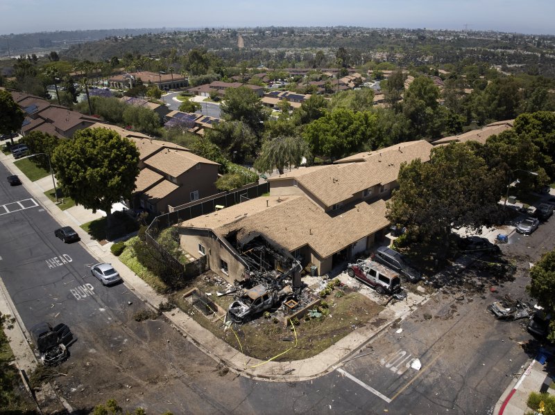 Debris covers the ground after a small plane crashed into a San Diego neighborhood, setting homes and cars on fire and forcing evacuations early Thursday, May 22, 2025. (AP Photo/William Liang)