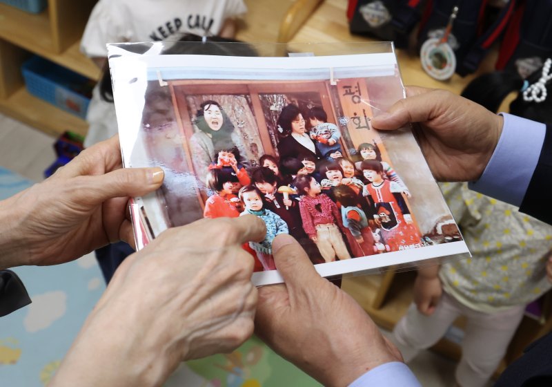 [광명=뉴시스] 고승민 기자 = 김문수 국민의힘 대선 후보와 설난영 여사가 22일 경기 광명시의 한 어린이집에서 아이들을 만나던 중 딸 동주 씨의 어린시절 사진을 보고 있다. 2025.05.22. kkssmm99@newsis.com