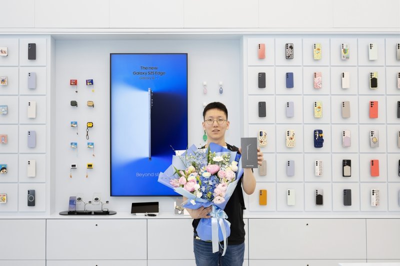 [서울=뉴시스] 지난 21일부터 '갤럭시 S25 엣지' 사전 개통이 시작됐다. 사진은 이날 서울 서초구 삼성 강남에서 갤럭시 S25 엣지 1호 수령 고객이 된 전준하 씨 모습. (사진=삼성전자 뉴스룸 제공)