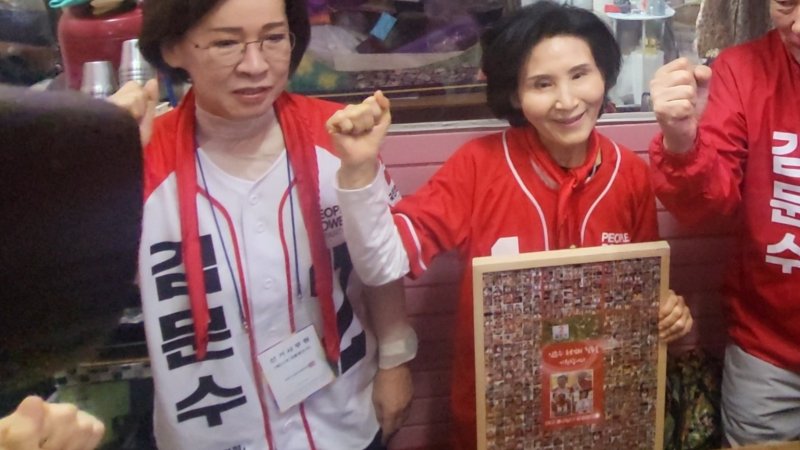 24일 김문수 국민의힘 대통령 후보 배우자 설난영 여사가 대구 중구 서문시장에 있는 칼국숫집에서 중남구 당협협의회가 전달한 액자를 전달받고 기념 사진을 촬영하고 있다. 2025.5.24/뉴스1 ⓒ News1 이성덕 기자