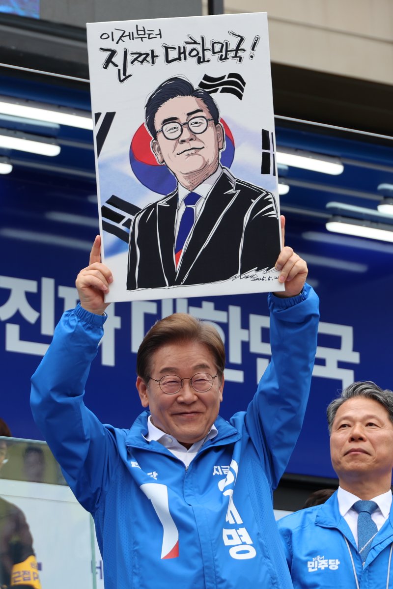 [부천=뉴시스] 조성봉 기자 = 이재명 더불어민주당 대통령 후보가 24일 오후 경기도 부천시 부천역 북부광장에서 열린 유세에서 시민에게 선물받은 캐리커쳐를 들어보이고 있다. (공동취재) 2025.05.24. photo@newsis.com