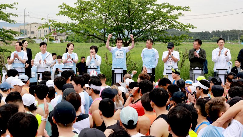 [보령=뉴시스] '제22회 보령머드임해마라톤대회'에 출전한 김동일(가운데) 보령시장이 파이팅을 외치는 모습. (사진=보령시청 제공) *재판매 및 DB 금지