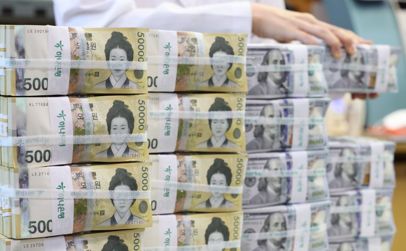 [서울=뉴시스] 황준선 기자 = 22일 서울 중구 하나은행 위변조대응센터에서 직원이 달러화와 원화를 정리하고 있다. 원·달러 환율이 1370원대에 진입하며 6개월여 만에 최저 수준으로 하락하는 등 무디스의 미국 신용등급 강등에 미국의 경기 균열과 재정 적자 우려로 달러화가 약세를 보이고 있다. 2025.05.22. hwang@newsis.com