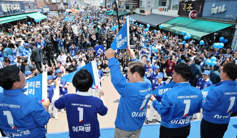 이재명 더불어민주당 대통령 후보가 26일 오후 경기 수원시 팔달문 영동시장 입구를 찾아 '진짜 대한민국'이라고 적힌 깃발을 들고 있다. 2025.5.26/뉴스1 ⓒ News1 안은나 기자