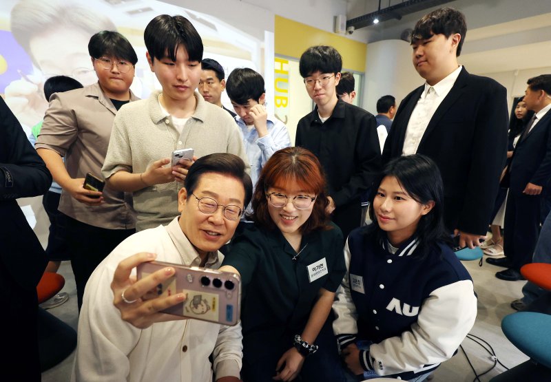 이재명 더불어민주당 대통령 후보가 26일 경기 수원시 아주대학교에서 대학생 간담회를 마친 뒤 참석 학생들과 셀카를 찍고 있다. (공동취재) 2025.5.26/뉴스1 ⓒ News1 안은나 기자