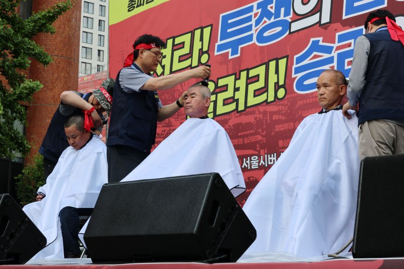26일 서울 송파구 교통회관 앞에서 열린 서울시버스노조 총파업 투쟁 승리쟁취 버스노동자 결의대회에서 교섭위원들이 삭발식을 하고 있다. /뉴스1