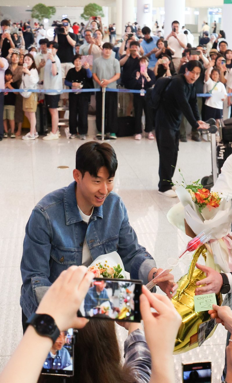 [인천공항=뉴시스] 김선웅 기자 = 유로파리그에서 우승한 토트넘의 손흥민이 27일 인천국제공항을 통해 귀국하며 팬에게 꽃다발을 전달받고 있다. 2025.05.27. mangusta@newsis.com