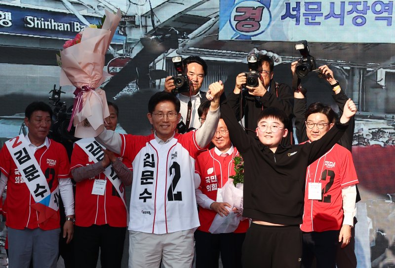 제21대 대통령 선거 공식 선거운동 첫날인 12일 김문수 국민의힘 대통령 후보가 대구 중구 서문시장에서 유세도중 학생과 손을 들어보이고 있다. 2025.5.12/뉴스1 ⓒ News1 김민지 기자