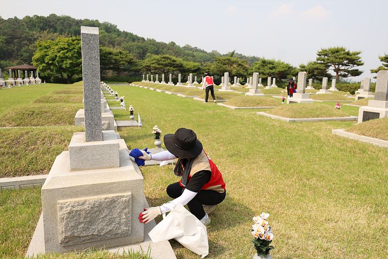 롯데이노베이트임직원들이 지난 28일 현충원 묘역 단장 봉사를 하고 있다. 롯데이노베이트 제공