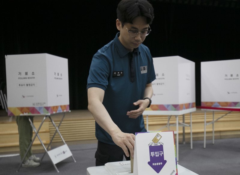 제21대 대통령선거 사전투표 첫날인 29일 오전 울산 남구청 6층에 마련된 사전투표소에 한 경찰관이 투표함에 투표 용지를 넣고 있다.2025.5.29/뉴스1 ⓒ News1 김지혜 기자