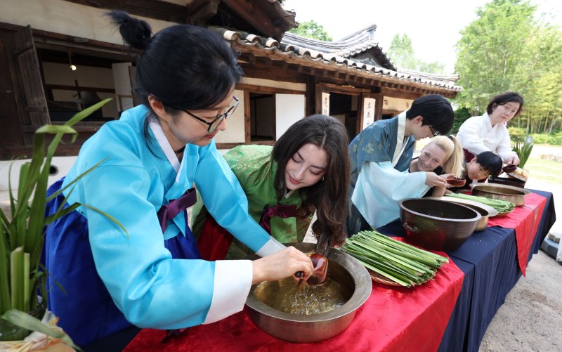 [서울=뉴시스] 김선웅 기자 = 단오(음력 5월 5일)를 이틀 앞둔 29일 서울 종로구 국립민속박물관 오촌댁 앞마당에서 열린 단오 세시행사에서 방문객들이 창포물 머리감기 체험을 하고 있다. 2025.05.29. mangusta@newsis.com