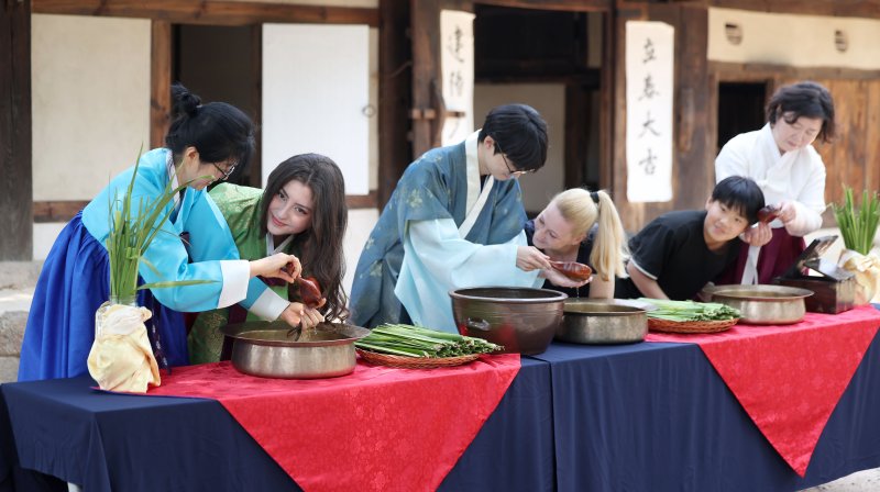 [서울=뉴시스] 김선웅 기자 = 단오(음력 5월 5일)를 이틀 앞둔 29일 서울 종로구 국립민속박물관 오촌댁 앞마당에서 열린 단오 세시행사에서 방문객들이 창포물 머리감기 체험을 하고 있다. 2025.05.29. mangusta@newsis.com