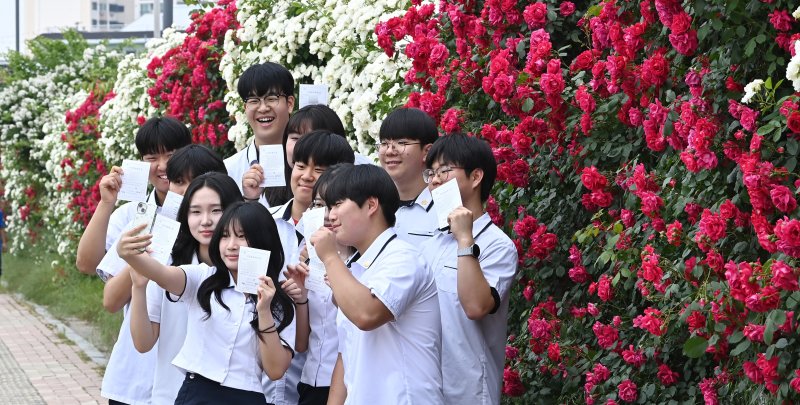 [수원=뉴시스] 김종택기자 = 제21대 대통령선거 사전투표 첫날인 29일 경기 수원시 연무동 행정복지센터에 마련된 사전투표소에서 삼일공업고등학교 3학년 학생 유권자들이 생애 첫 투표를 마친 뒤 장미꽃 앞에서 인증샷을 남기고 있다. 2025.05.29. jtk@newsis.com