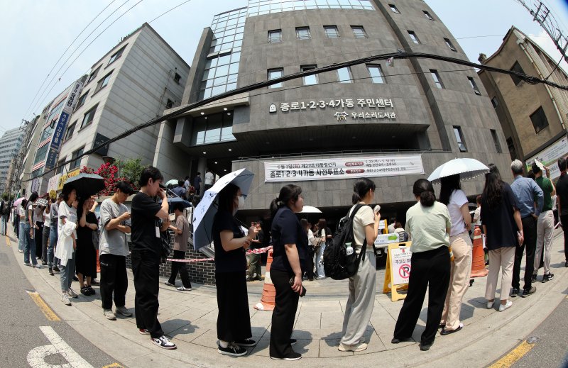제21대 대통령선거 사전투표 첫 날인 29일 서울 종로구 종로1·2·3·4가동 주민센터 투표소에 마련된 투표소에서 직장인들이 점심시간을 이용해 투표를 위해 길게 줄을 늘어서 있다. 2025.5.29/뉴스1 ⓒ News1 이동해 기자