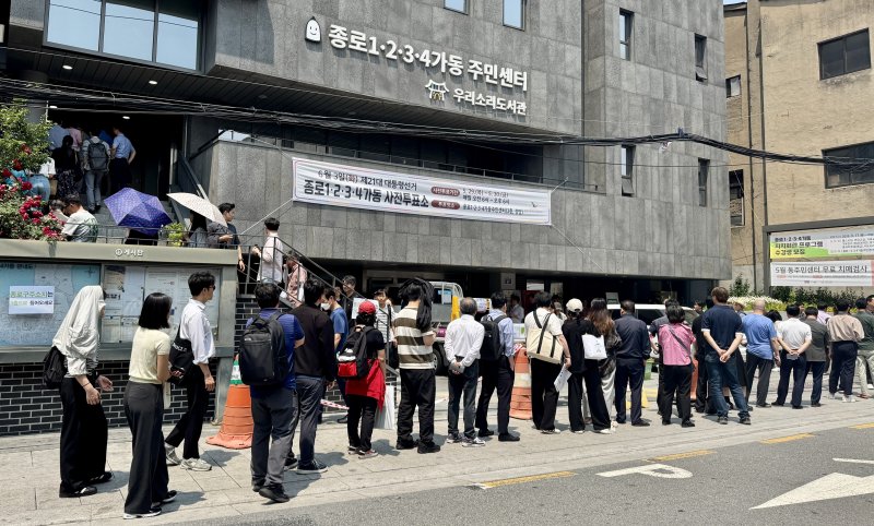 제21대 대통령선거 사전투표 첫 날인 29일 서울 종로구 종로1·2·3·4가동 주민센터 투표소에 마련된 투표소에서 직장인들이 점심시간을 이용해 투표를 위해 길게 줄을 늘어서 있다. 사전투표 첫날 오후 1시 기준 전국 평균 투표율은 지난 20대 대선(36.93%)의 같은 시각 투표율(8.75%)보다 1.76% 높은 10.51%로 역대 최고치다. 2025.5.29/뉴스1 ⓒ News1 유승관 기자