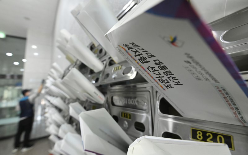 [수원=뉴시스] 김종택 기자 = 18일 경기 수원시 권선구 한 오피스텔 건물에서 우체국 집배원이 제21대 대통령선거 안내문과 선거공보물을 우편함에 넣고 있다. 2025.05.18. jtk@newsis.com