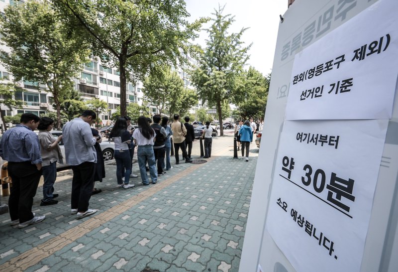 [서울=뉴시스] 정병혁 기자 = 제21대 대통령선거 사전투표 첫 날인 29일 서울 영등포구 여의동주민센터에 설치된 사전투표소를 찾은 유권자들이 투표를 하기 위해 줄 서 있다. 2025.05.29. jhope@newsis.com