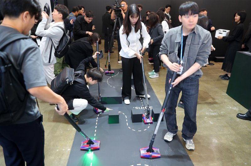 [서울=뉴시스] 김혜진 기자 = 26일 오전 서울 성동구 무신사스퀘어성수4에서 열린 다이슨 신제품 청소기 '펜슬백' 공개 행사에서 관계자들이 제품을 체험하고 있다. 2025.05.26. jini@newsis.com