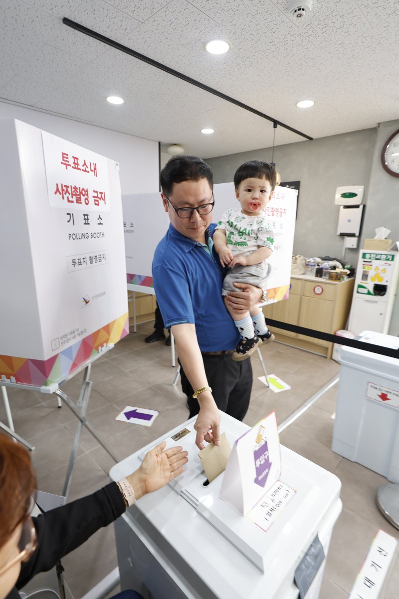 제21대 대통령 선거 사전투표 둘째날인 30일 광주시 광산구 평동 드림센터 사전투표소에서 아빠를 따라온 아들이 함께 한 표를 행사하고 있다 2025.5.30/뉴스1 ⓒ News1 김태성 기자